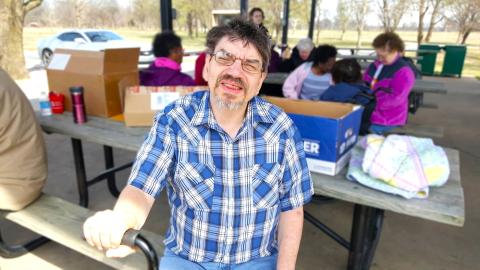 man in blue plaid t-shirt outdoors at event
